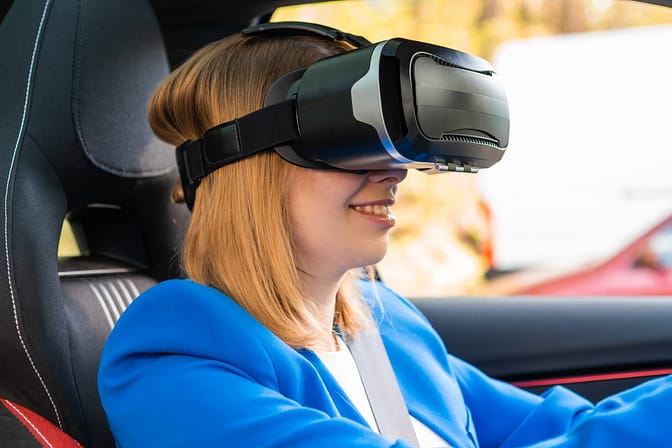 business woman in the vr googles sitting in the car and turning the steering wheel in a car